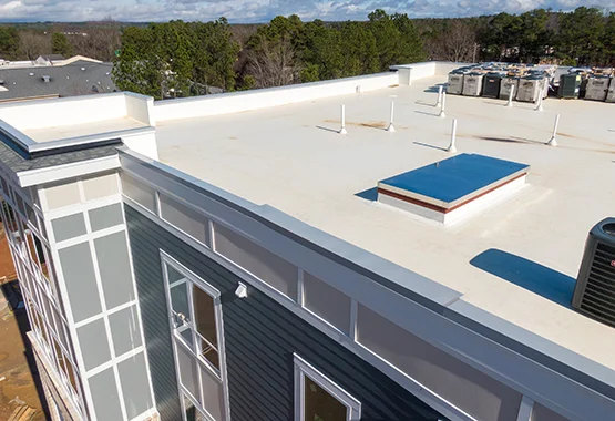 Flat roof on a multi-story building with a skylight curb and rooftop equipment