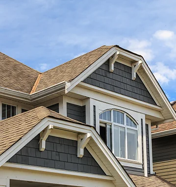 Gray two-story house with dormers and a shingle roof