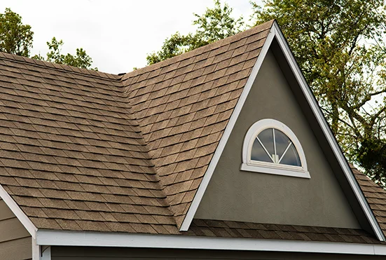 Brown shingle roof with a brick chimney and gable