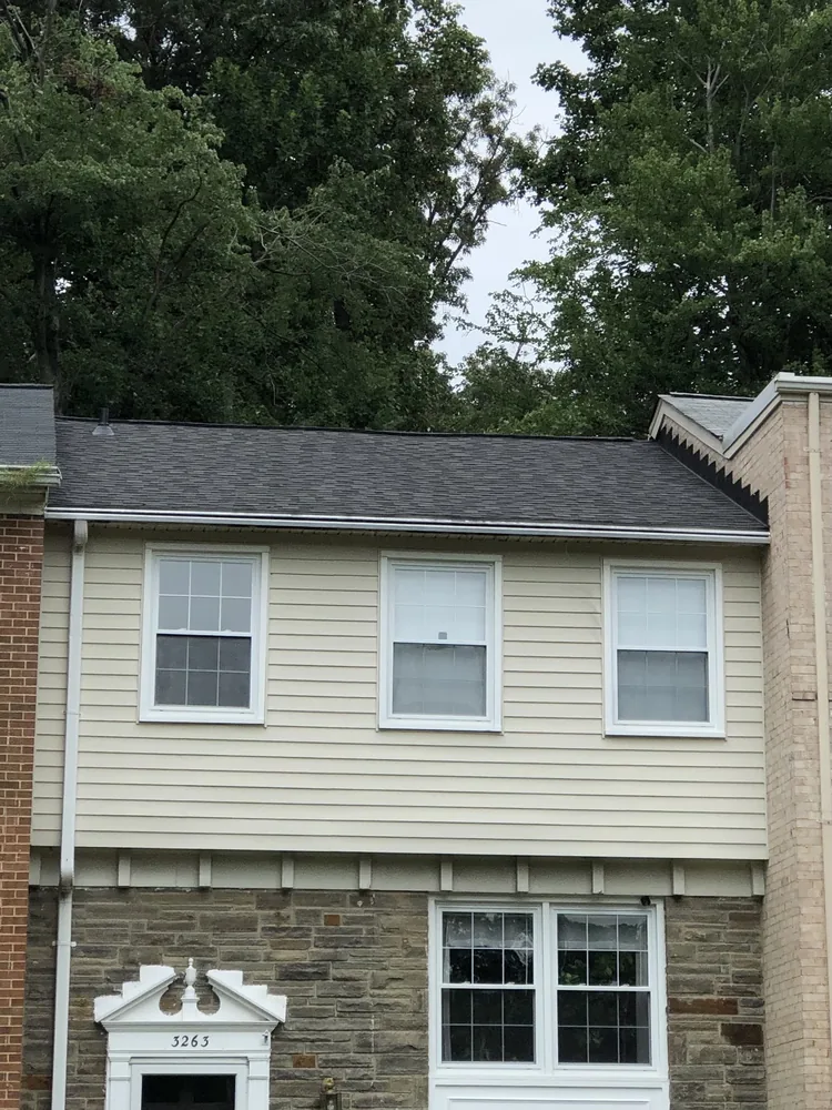 Dark architectural shingle roof on a brick and stone townhouse